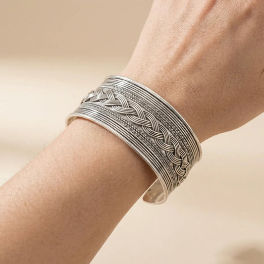 Miao Silver braided bracelet on a wrist against a beige background