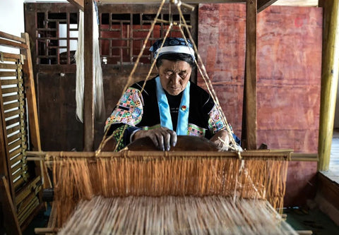 Close view of a Miao artisan weaving fabric on a traditional loom