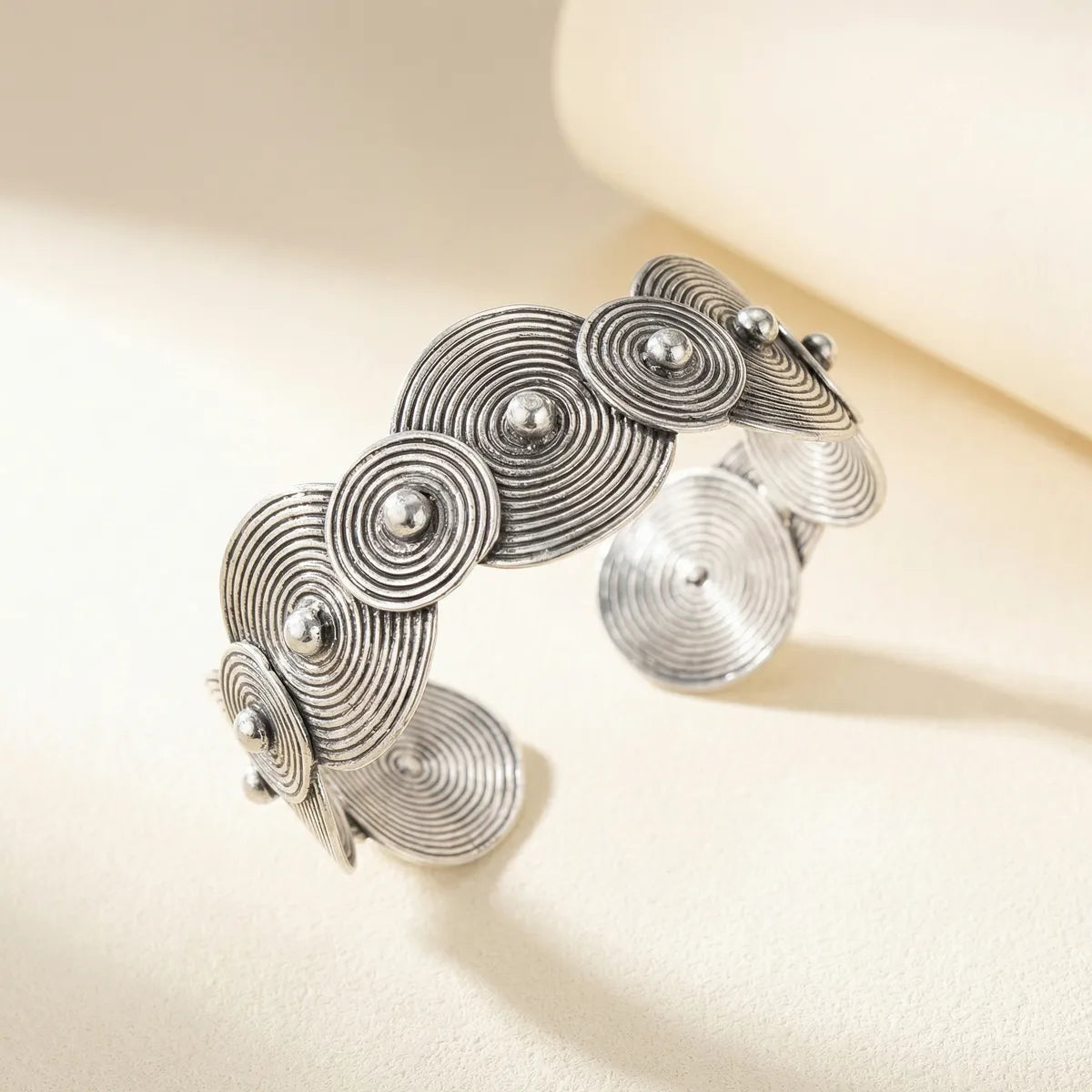 Miao Silver bracelet with circular design on a beige background