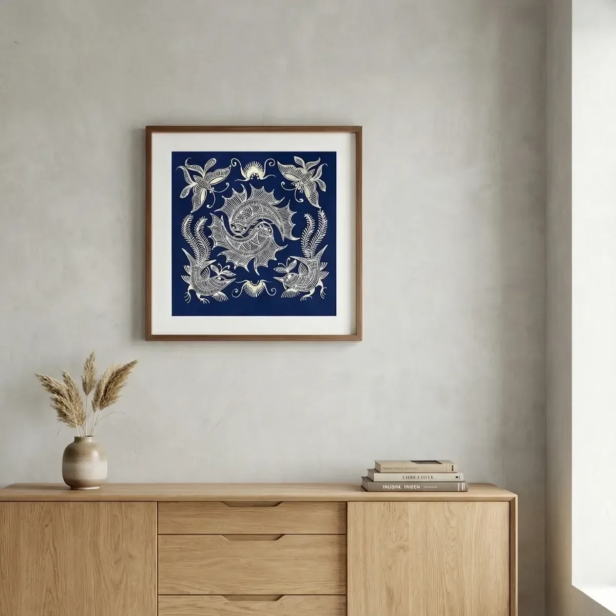 Tableau carré en batik indigo encadré et centré au-dessus d'un buffet en bois clair
